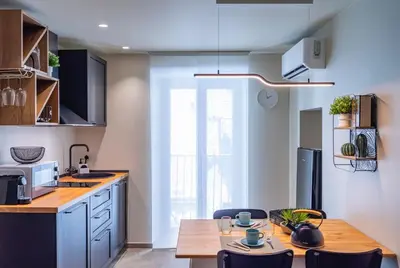 a kitchen with a wooden table and a dining room at Meschita Sette in Palermo