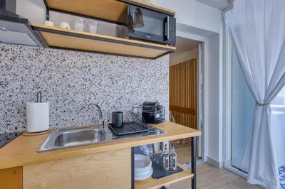 a kitchen with a sink and a microwave at VFH La Rada Apartments in Santa Flavia