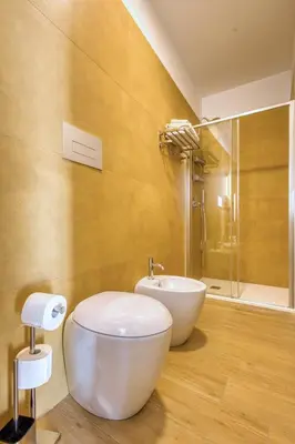 a bathroom with a white toilet and a sink at VFH La Rada Apartments in Santa Flavia