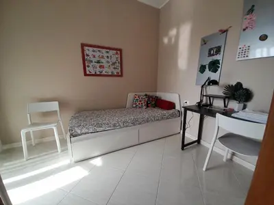 a bedroom with a bed and a desk and a chair at La stanza del buonriposo in Palermo