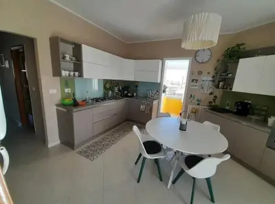 a kitchen with a white table and white chairs at La stanza del buonriposo in Palermo