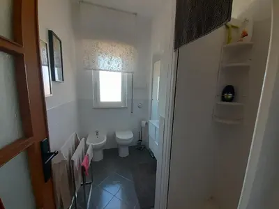 a white bathroom with a toilet and a window at La stanza del buonriposo in Palermo