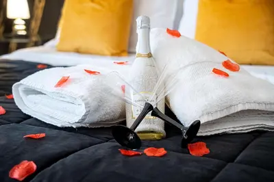 a bottle of champagne and hearts on a bed at Suite del Corso in Ficarazzi