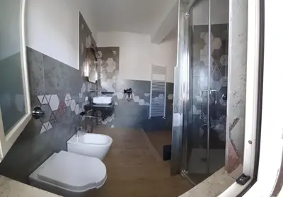 a bathroom with a toilet and a shower and a sink at House Dotto 25 Apartment in Palermo
