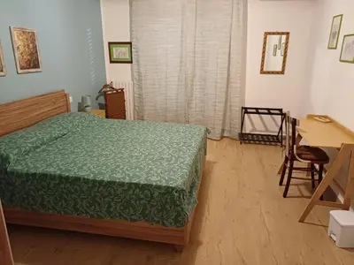 a bedroom with a bed and a table and a desk at House Dotto 25 Apartment in Palermo