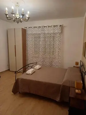 a bedroom with a bed and a chandelier at House Dotto 25 Apartment in Palermo