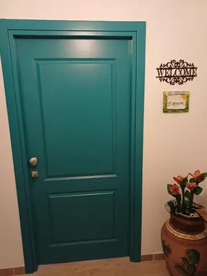 a green door in a room with a plant at Dotto 25 Apartment in Palermo