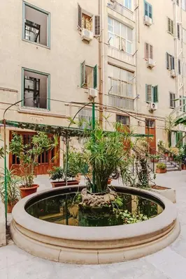 a fountain in a courtyard in front of a building at Sofia's House - Comfort e Relax vicino Stazione Notarbartolo in Palermo