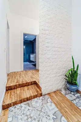 a living room with a wooden floor and white walls at Sofia's House - Comfort e Relax vicino Stazione Notarbartolo in Palermo