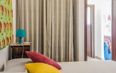 a bedroom with a bed with red and yellow pillows at Casetta San Giovanni in Giuliana