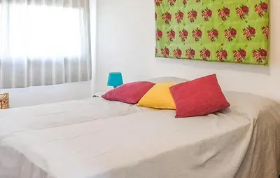 a bed with two red and yellow pillows on it at Casetta San Giovanni in Giuliana
