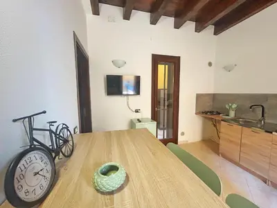 a dining room with a wooden table with a clock at Casa Didi - Cattedrale in Palermo