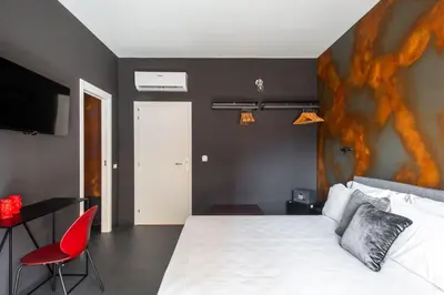 a bedroom with a white bed and a red chair at Massimo Foyer 53 by Wonderful Italy in Palermo