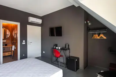a bedroom with a bed and a red chair at Massimo Foyer 53 by Wonderful Italy in Palermo