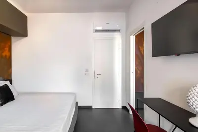 a bedroom with a white bed and a red chair at Massimo Foyer 53 by Wonderful Italy in Palermo