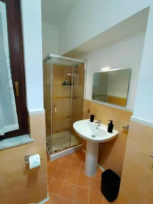 a bathroom with a sink and a glass shower at Casa Marite' in Palermo