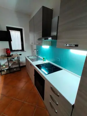 a living room with a red couch and a kitchen at Casa Marite' in Palermo