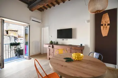 a dining room with a wooden table and a television at iFlat Casa di Design nella piazzetta in Palermo