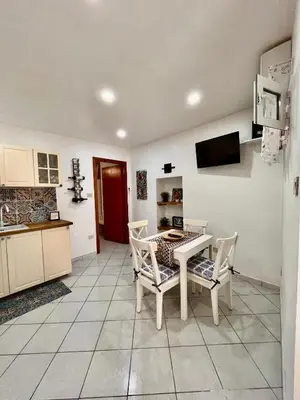 a kitchen with a table and chairs in a room at Scala Dei Normanni in Palermo
