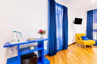 a blue desk and a yellow chair in a room at Balarm-Boutique Rooms in Palermo