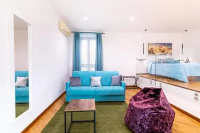 a living room with a blue couch and a bed at Balarm-Boutique Rooms in Palermo