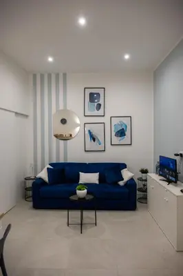 a bedroom with a bed and a blue chair at A casa da Carlo al Borgo 1 in Palermo