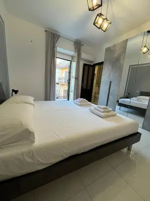 a bedroom with a large white bed with a mirror at D'Aversa Rooms in Marineo