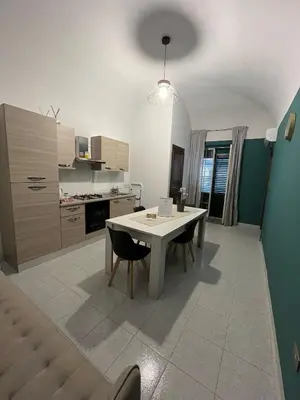 a kitchen with a table and chairs in a room at D'Aversa Rooms in Marineo