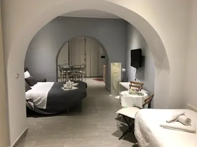 a room with two beds and a table and chairs at Al Bastione Holiday House in Palermo
