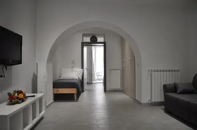 a living room with a bed and a couch at Al Bastione Holiday House in Palermo