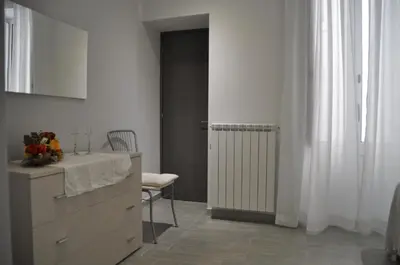a kitchen with a dresser and a table and a chair at Al Bastione Holiday House in Palermo