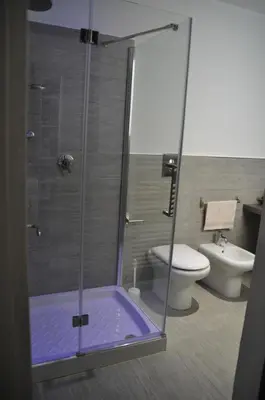 a bathroom with a shower with a toilet and a sink at Al Bastione Holiday House in Palermo