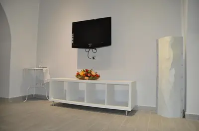 a flat screen tv on top of a white cabinet at Al Bastione Holiday House in Palermo