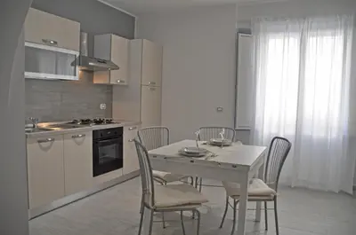 a kitchen with a white table and chairs in a kitchen at Al Bastione Holiday House in Palermo