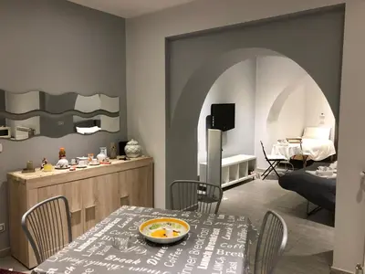 a living room with a table and a kitchen at Al Bastione Holiday House in Palermo