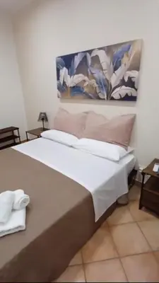 a bedroom with a large bed with a painting on the wall at Monreale Prestige Rooms B&B in Monreale
