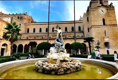 a fountain with a statue in front of a building at Monreale Prestige Rooms B&B in Monreale