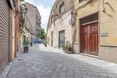 an empty street in an alley with buildings at Candelai Apartments by Wonderful Italy in Palermo