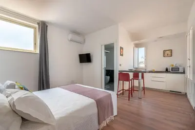 a hotel room with a bed and a kitchen at Candelai Apartments by Wonderful Italy in Palermo