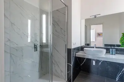 a bathroom with a sink and a glass shower at Candelai Apartments by Wonderful Italy in Palermo