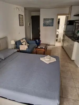 a bedroom with a large bed and a living room at Goodnight Palermo in Palermo