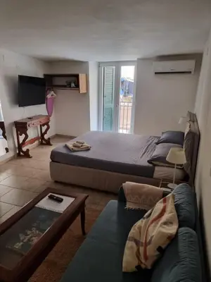a bedroom with a bed and a couch and a table at Goodnight Palermo in Palermo