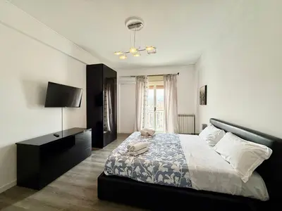 a bedroom with a large bed and a television at La Coccola in Palermo