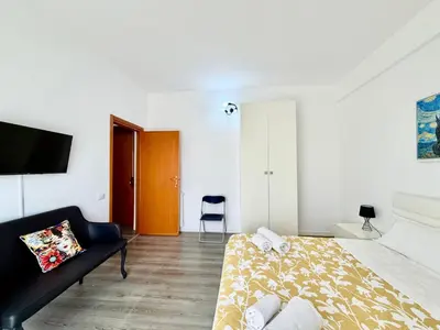 a bedroom with a bed and a couch and a tv at La Coccola in Palermo