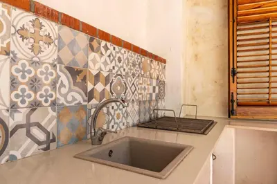 a kitchen with a sink and a tile wall at Casa D'Acquisto in Santa Flavia