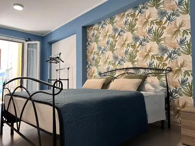 a bedroom with a bed with a floral wallpaper at M'AMA apartment 3 in Ficarazzi