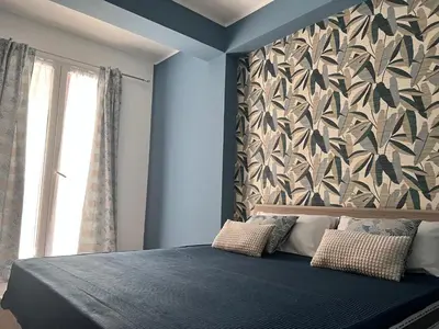 a bedroom with a blue bed with a wall at M'AMA apartment 3 in Ficarazzi