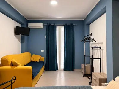 a living room with a yellow couch and blue walls at M'AMA apartment 3 in Ficarazzi