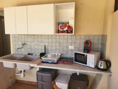 a kitchen counter with a sink and a microwave at Le Case di Sole San Vito Lo Capo in San Vito lo Capo