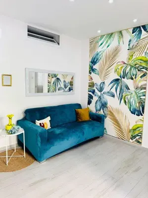 a blue couch in a living room with a mural at Ciuri D'Amuri in Palermo